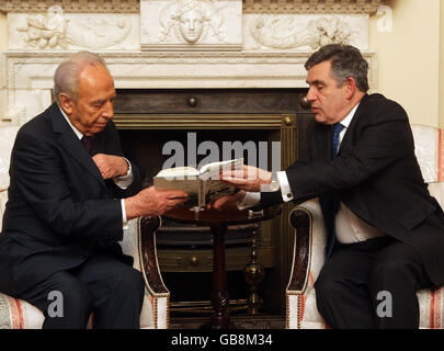 Der britische Premierminister Gordon Brown (rechts) weist dem israelischen Präsidenten Shimon Peres in der Downing Street 10 in London auf ein Kapitel in seinem Buch "Kriegsmut" hin. Stockfoto