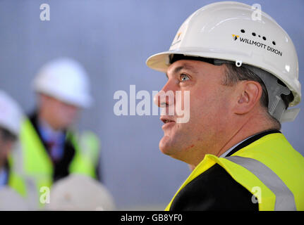 Der Staatssekretär für Kinder, Schulen und Familien, Ed Balls, wird bei einem Besuch der John Perryn School in Ealing, London, durch ein neues Gebäude geführt. Stockfoto