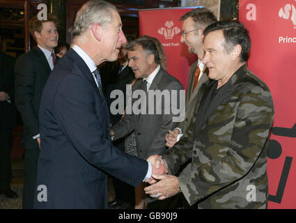 Prinz Charles schüttelt sich die Hände mit dem Schauspieler Robin Williams, begleitet von Prinz Harry (links, hinten) im Wimbledon Theater für eine Wohltätigkeitsveranstaltung zur Unterstützung der Prince's Trust Charity in London, eine von mehreren Veranstaltungen zur Feier des 60. Geburtstages des Prinzen am 14. November. Stockfoto