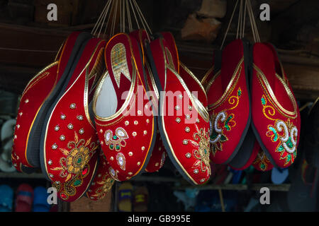 Rote Sandalen hängen im Shop von Nepal zu verkaufen. Stockfoto