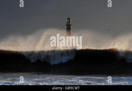 Sturmwellen treffen den Leuchtturm von Seaham in Sunderland, während eine arktische Wetterfront die Ostküste trifft. Stockfoto