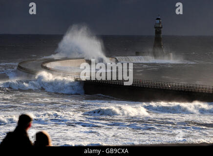 Die Menschen beobachten, wie Sturmwellen den Leuchtturm von Seaham in Sunderland treffen, während eine arktische Wetterfront die Ostküste trifft. Stockfoto