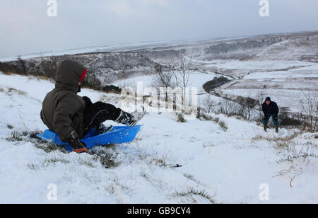 Kinder spielen im Schnee am Hole-of-Horcum im North Yorkshire Moors National Park, während eine arktische Wetterfront Großbritannien trifft. Stockfoto