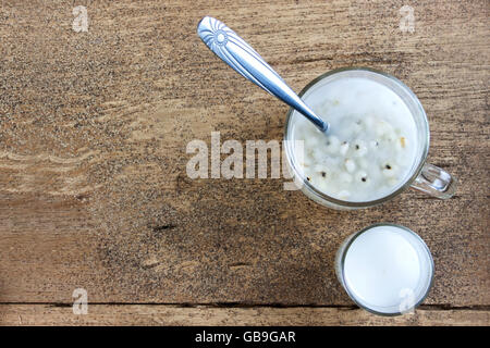 Job's-Tränen mit Kokosmilch in Glas auf Holztisch. Thai dessert Stockfoto