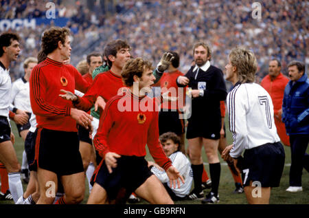 Der Westdeutsche Pierre Littbarski (r) wird von mehreren zornitanischen Spielern konfrontiert, während Teamkollege Rudi voller (c, am Boden) zurückblickt Stockfoto