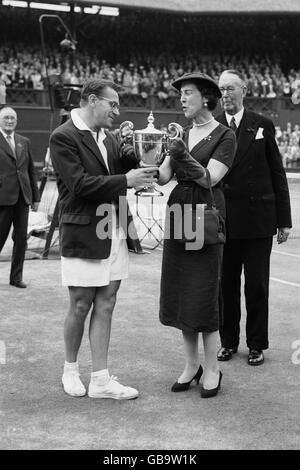 Der gebürtige Tscheche Jaroslav Drobny, der jetzt unter Ägyptens Banner spielt, lächelt, als er die Trophäe von der Herzogin von Kent erhält, nachdem er den Australier Ken Rosewall im Finale besiegt hat. Stockfoto