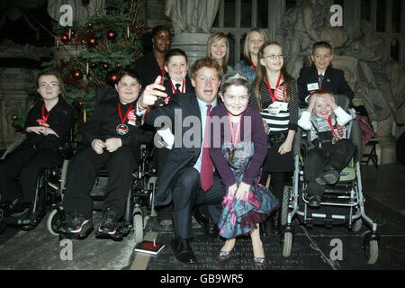 Prinz Harry mit (von links) Evangeline Edwards, Edward Common, Tara Ifill , William John, Lucy Long (über Prinz Harry's Knee), Bonnie Long, Charlotte Long, Courtney Taylor, Keaton Peppiatt und Rupert Parsons (im Stuhl) in Westminster Abbey, London nach dem Women's Own Children of Courage Award 2008. Stockfoto