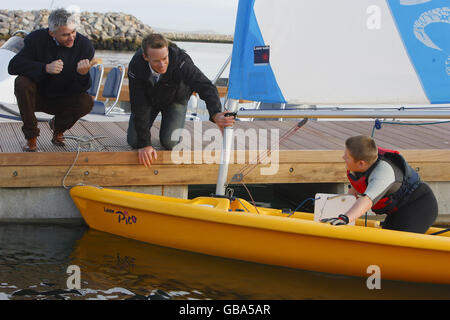 Peking Goldmedaillengewinner britischer Segler Paul Goodison und olympischer Goldmedaillendreispringer Jonathan Edwards (links) mit dem 12-jährigen Segler Adam Greaves bei der Enthüllung der neuen Segeleinrichtungen in Weymouth & Portland National Sailing Academy, Dorset. Stockfoto