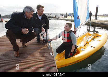 Der britische Segler Paul Goodison (Mitte) und der olympische Dreifachspringer Jonathan Edwards (links) mit dem 12-jährigen Segler Adam Greaves wurden während der Enthüllung der neuen Segeleinrichtungen in Weymouth & Portland National Sailing Academy, Dorset, mit einer Goldmedaille ausgezeichnet. Stockfoto