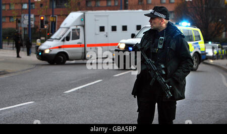 Ein Polizist steht Wache, während ein eskortiertes Sicherheitsfahrzeug vor dem Birmingham Crown Court ankommt. Stockfoto