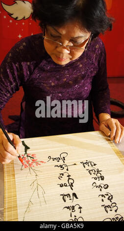 Frau schreiben Kalligraphie, sie schreiben vietnamesische Jahr Endereignis, Kalligraph, die Art konfrontiert, geistigen Verschleiß tra Stockfoto
