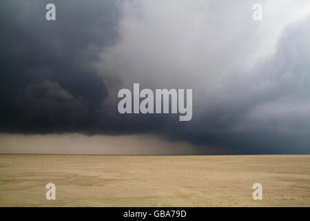 Dunkle, bedrohliche Wolken über einem riesigen Strand Stockfoto