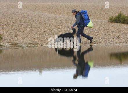 SEB Green, 19, aus Weymouth, der fast ein Jahr seines Lebens mit seinem Border Collie Flash mehr als 3,100 Meilen um Großbritannien herumgelaufen ist, spazieren entlang des Chesil Beach in Dorset, während sie sich ihrem endgültigen Ziel Weymouth nähern und ihre Umrundung der Küste des britischen Festlandes abschließen. Stockfoto