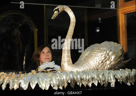 Museumsarbeiter Rachael Metcalfe betrachtet den unbezahlbaren, lebensgroßen, soliden silbernen musikalischen Schwan, der nach einer dreimonatigen Reinigung und Politur wieder im Bowes Museum, Barnard Castle, Co Durham ausgestellt wird. Stockfoto