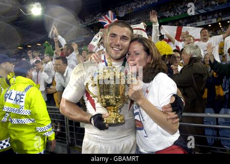 Rugby Union - Weltmeisterschaft 2003 - Finale - England gegen Australien. Der englische Ben Cohen feiert mit seinem Partner und der William Webb Ellis Trophy Stockfoto