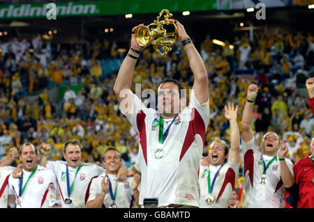 Rugby Union - Weltmeisterschaft 2003 - Finale - England gegen Australien. England Kapitän Martin Johnson feiert mit der WM Webb Ellis Trophäe viel zur Freude seiner Spieler Stockfoto