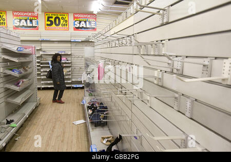 Eine Frau schaut sich Artikel in den Regalen eines Woolworths-Ladens in Camden, London, an, während das Unternehmen Schwierigkeiten hat, einen Käufer für seine Filialkette zu finden. Stockfoto