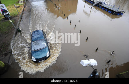 Nach sintflutartigen Regenfällen am Wochenende wird ein Auto durch das aufsteigende Flutwasser des Flusses Ouse in York gefahren. Stockfoto