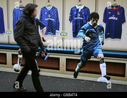 Ein Chelsea-Fan kommt vor dem Anpfiff an einem Plakat des ehemaligen Cheslea-Spielers und aktuellen West Ham United-Managers Gianfranco Zola vorbei. Stockfoto