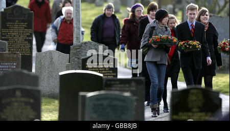 Mitglieder der Gemeinde nehmen an einer Kranzniederlegung im Garten des Gedenkens in Tundergarth Teil, um den 20. Jahrestag der Luftkatastrophe von Lockerbie zu begehen. Stockfoto