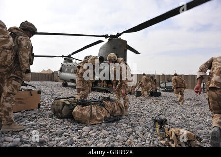 Die Truppen bringen Taschen von einem Chinook-Hubschrauber, der von Camp Bastion abgeflogen ist, und bringen sie in die Forward Operating Base (FOB) Dehli, Bezirk Garmsir, Provinz Helmand, Afghanistan Stockfoto