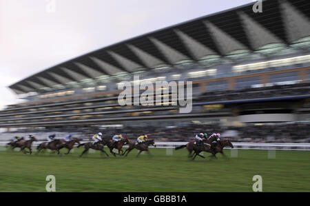 Läufer und Reiter passieren die Tribüne auf der Ascot Racecourse in Bekshire. Stockfoto