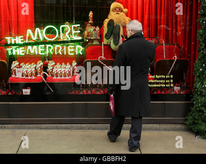 Ein Weihnachtskäufer schaut auf die Schaufenster von Selfridges in der Oxford Street, London, während Weihnachtskäufer vor dem Weihnachtstag nach Last-Minute-Geschenken suchen. Stockfoto