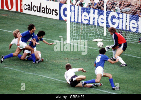 Der Italiener Paolo Rossi (3. Links) zwingt den Ball an Westdeutschland-Torwart Harald Schumacher (2. R) vorbei, um das Eröffnungstor zu erzielen. Stockfoto