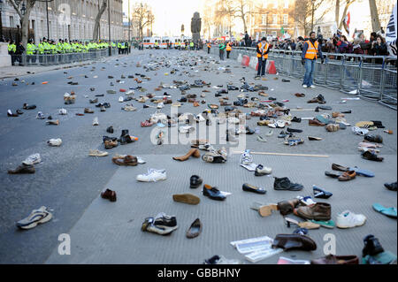 Hunderte von Schuhen liegen auf der Straße in Whitehall, nachdem Demonstranten versucht hatten, Schuhe in die Downing Street in London zu werfen. Die Demonstranten demonstrieren gegen die Bombardierung von Gaza und fordern ein sofortiges Ende der israelischen Angriffe. Stockfoto