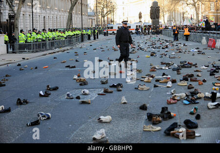 Hunderte von Schuhen liegen auf der Straße in Whitehall, nachdem Demonstranten versucht hatten, Schuhe in die Downing Street in London zu werfen. Die Demonstranten demonstrieren gegen die Bombardierung von Gaza und fordern ein sofortiges Ende der israelischen Angriffe. Stockfoto