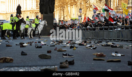 Hunderte von Schuhen liegen auf der Straße in Whitehall, nachdem Demonstranten versucht hatten, Schuhe in die Downing Street in London zu werfen. Die Demonstranten demonstrieren gegen die Bombardierung von Gaza und fordern ein sofortiges Ende der israelischen Angriffe. Stockfoto