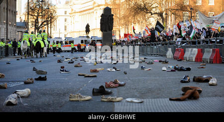 Hunderte von Schuhen liegen auf der Straße in Whitehall, nachdem Demonstranten versucht hatten, Schuhe in die Downing Street in London zu werfen. Die Demonstranten demonstrieren gegen die Bombardierung von Gaza und fordern ein sofortiges Ende der israelischen Angriffe. Stockfoto