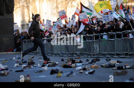 Hunderte Schuhe liegen in Whitehall auf der Straße, als ein Protestler zur Menge zurückläuft, nachdem er versucht hat, einen Schuh in die Downing Street in London zu werfen. Die Demonstranten demonstrieren gegen die Bombardierung von Gaza und fordern ein sofortiges Ende der israelischen Angriffe. Stockfoto