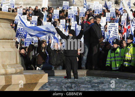 Ein pro-palästinensischer Protestler sticht, während er vor pro-israelischen Demonstranten auf einer pro-israelischen Kundgebung auf dem Trafalgar Square in London steht. Stockfoto