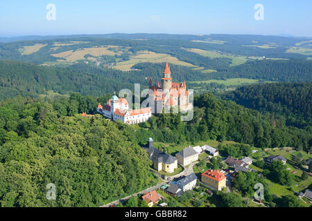 LUFTAUFNAHME. Mittelalterliche Burg in einer Landschaft von grünen Hügeln. Burg Bouzov, Bezirk Olomouc, Mähren, Tschechische Republik. Stockfoto