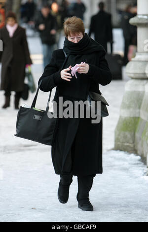 Ein Fußgänger geht vorsichtig auf einem eisigen Bürgersteig in der Fleet Street in London, während die Londoner nach einem Tag voller Störungen durch starken Schneefall wieder zur Arbeit zurückkehren. Stockfoto