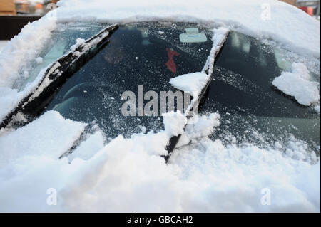 Ein Fahrer, der Schnee von der Windschutzscheibe des Autos in Northampton entfernt. Stockfoto