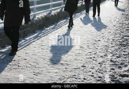 Winterwetter. Pendler überqueren die Waterloo Bridge im Zentrum von London. Stockfoto