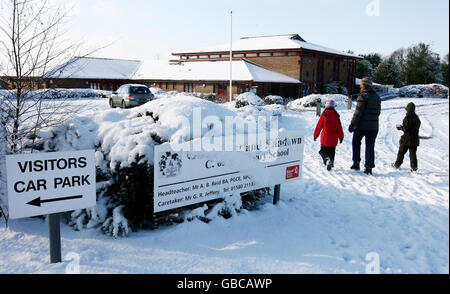 Ein Familienspaziergang an der geschlossenen Goudhurst und Kilndown School in Goudhurst, Kent, vorbei, da die Schulen heute geschlossen bleiben, nachdem gestern Schnee über das Land gefegt hat. Stockfoto