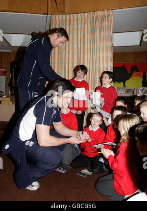 Die Mitglieder des schottischen Kaders Kelly Brown und Craig Hamilton unterschreiben Autogramme an der Balmullo Primary School Stockfoto