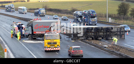 Ein Lastwagen und Anhänger auf seiner Seite auf der Autobahn M5 in der Nähe von Thornbury, sodass nur eine Spur in Richtung Süden für den Verkehr frei bleibt. Stockfoto