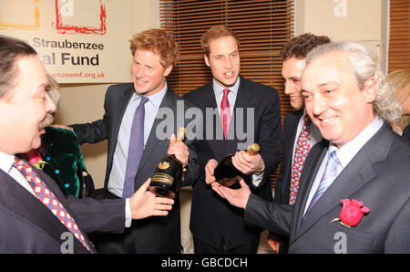 Prince William (Mitte rechts) und Prince Harry (Mitte links) erhalten bei der Eröffnung des Henry van Straubenzee Memorial Fund im Troubadour Club in London jeweils eine Flasche Champagner von einem Sponsor. Stockfoto