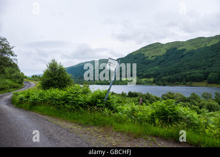 Vorbeifahrenden Ort Straßenschild auf schmalen einspurigen Landstraße an der Seite des Loch Doine in Schottland Stockfoto