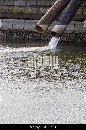 Schmutziges Wasser fließt aus einem Abflussrohr für Industrieabfälle Stockfoto