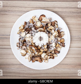 Dekoration von getrockneten Blumen auf den weißen Teller. Natürliche Schönheit. Spa Thema. Potpourri-Szene. Stockfoto