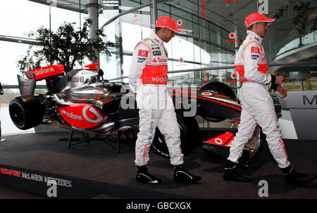 Vodafone McLaren Mercedes-Piloten Lewis Hamilton (links) und Heikki Kovalainen vor dem neuen McLaren MP4-24 während des McLaren Mercedes Formel-1-Starts im Technology Center in Woking, Surrey. Stockfoto