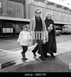 Der Schauspieler Peter Sellers nimmt am Flughafen Heathrow die Hand seiner Tochter Victoria und trägt ihre Puppe als Mutter Britt Ekland, Verkäuferin ehemalige Ehefrau. Stockfoto