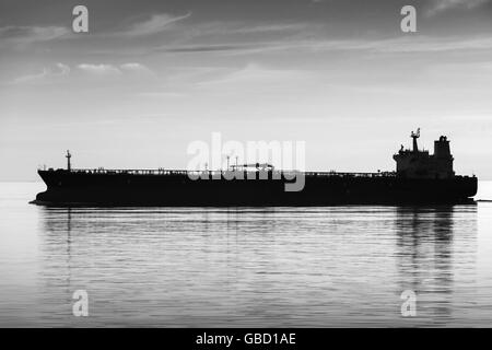 Große industrielle Tanker Schiff geht auf noch Meer Wasser, schwarze und weiße Silhouette Foto Stockfoto