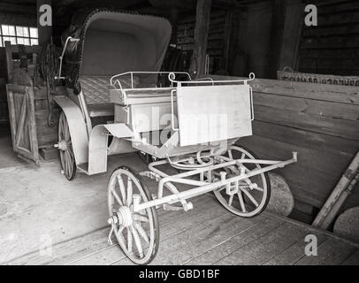 Vintage weiß Trainer steht im ländlichen Garage, schwarz / weiß Foto Stockfoto