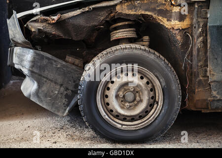 Verlassene verrosteten Auto, alte Rad und gebrochenen Rumpf Stockfoto